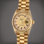 Reference 18038 Day-Date | A yellow gold and diamond and ruby-set automatic wristwatch with day, date, and bracelet, Circa 1981