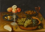 Still life of grapes in a dish, apples in a silver tazza and hazelnuts and medlars on pewter plates, on a wooden table