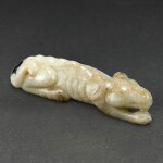 A BLACK AND GREY JADE FIGURE OF A RECUMBENT DOG EARLY QING DYNASTY | 清初 灰墨玉臥犬