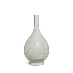 A carved white-glazed 'floral' bottle vase, Qing dynasty, 18th / 19th century | 清十八 / 十九世紀 白釉刻纏枝花卉紋長頸瓶