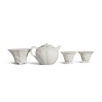 A group of three 'Dehua' cups and a 'Dehua' teapot and cover, Qing dynasty | 清 德化白瓷小杯一組三件及德化白瓷茶壺