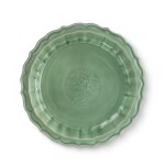 A 'Longquan' celadon-glazed barbed-rim 'peony' dish, Ming dynasty | 明 龍泉窰青釉印牡丹紋菱花式盤