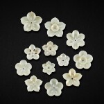 A group of twelve pale celadon jade 'floral' ornaments, Jin - Ming dynasty 金至明 青白玉花飾件一組十二件