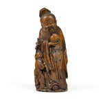 A large carved bamboo figure of Shoulao standing holding a peach with an attendant at his side Qing dynasty, 17th/18th century |  清十七/十八世紀 竹雕壽老
