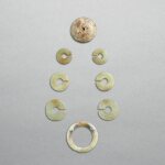 Four jade earrings, jue, a jade disc, bi, and a jade ring,  huan, Late Western Zhou dynasty - Eastern Zhou dynasty | 西周晚期至東周 龍紋玉玦、玉璧及絞絲玉環一組八件
