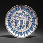 AN IZNIK POTTERY RIMLESS ‘GRAPE’ DISH, TURKEY, CIRCA 1570-80