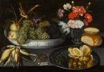 Still life of peaches and grapes in a porcelain bowl with a sparrow, alongside carnations in a glass vase, bread and a pewter dish with a sliced lemon, olives and capers,  a mouse eating sweet meats and dead songbirds, all upon a ledge 