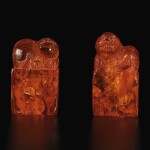 A pair of amber 'Buddhist lion' seals, Qing dynasty, 18th century | 清十八世紀 琥珀雕瑞獸鈕印料一對
