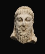 A ROMAN MARBLE ARCHAISTIC HERM HEAD OF DIONYSOS, CIRCA 2ND CENTURY A.D.
