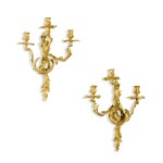 A pair of Louis XV style gilt-bronze three-light wall appliques, late 19th century, in the manner of Jacques Caffiéri