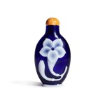 A white overlay cobalt-blue glass 'lily' snuff bottle, Qing dynasty, Qianlong period | 清乾隆 藍地套白料萱花紋鼻煙壺 